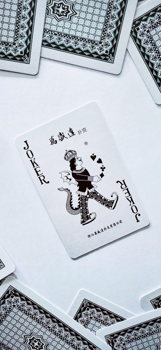 扑克牌游戏蜘蛛纸牌对局中界面截图，玩家手指正拖动一张红桃牌向左移动，底部撤销与提示按钮清晰可见，氛围专注安静